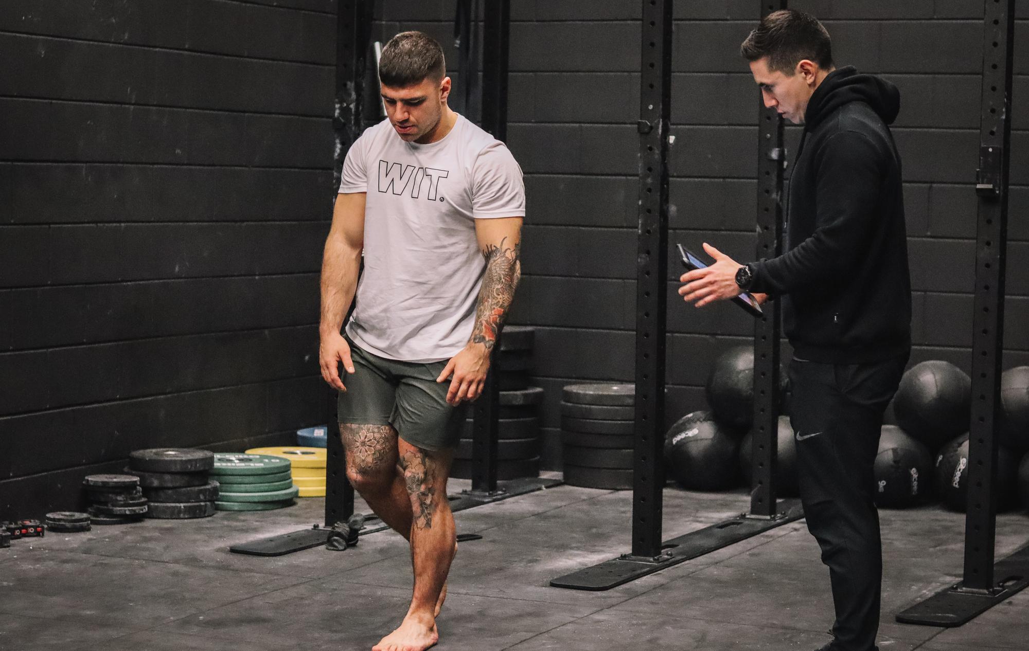 Ash Grossmann running a movement assessment with an athlete in the gym