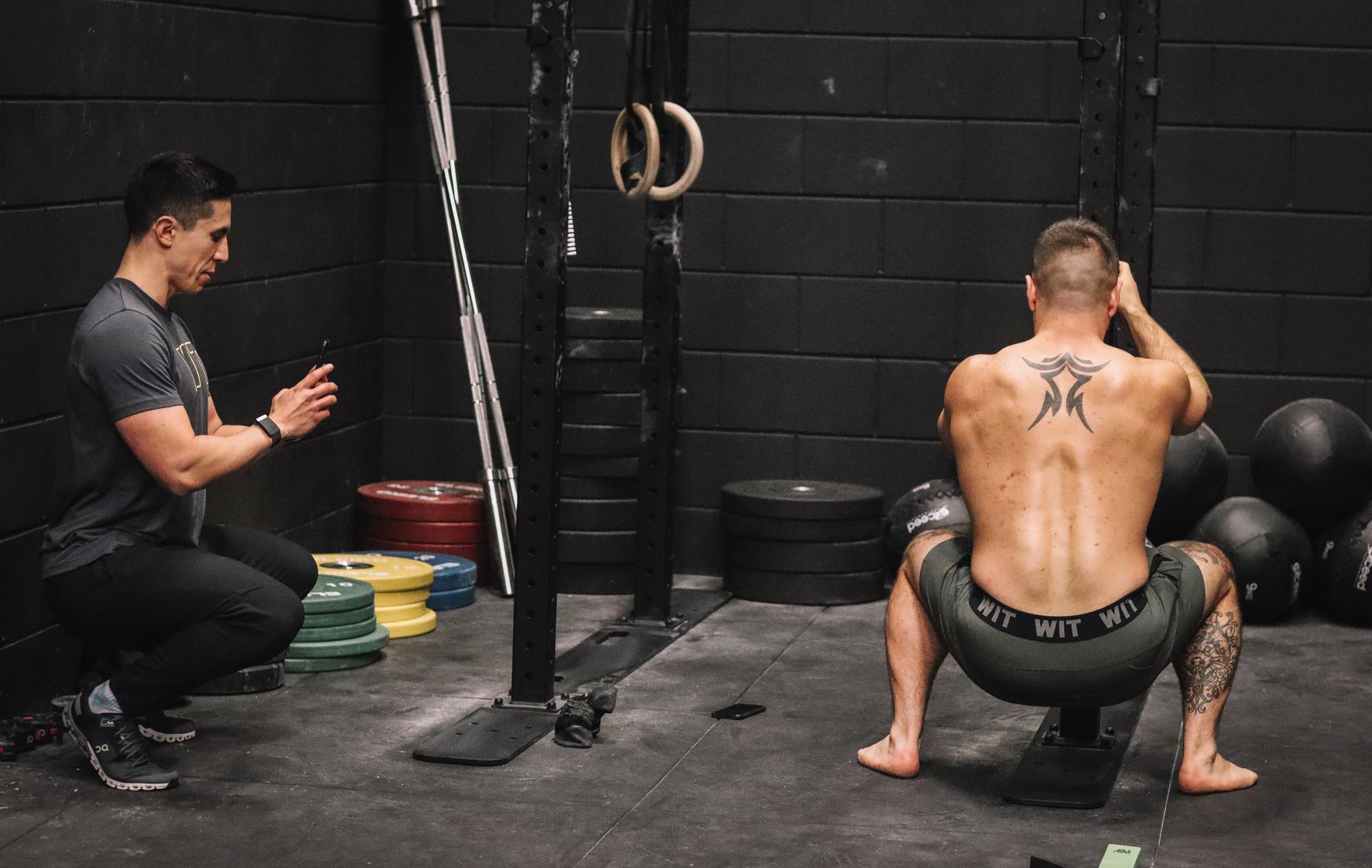 Ash Grossmann assessing an athlete\'s squat mechanics